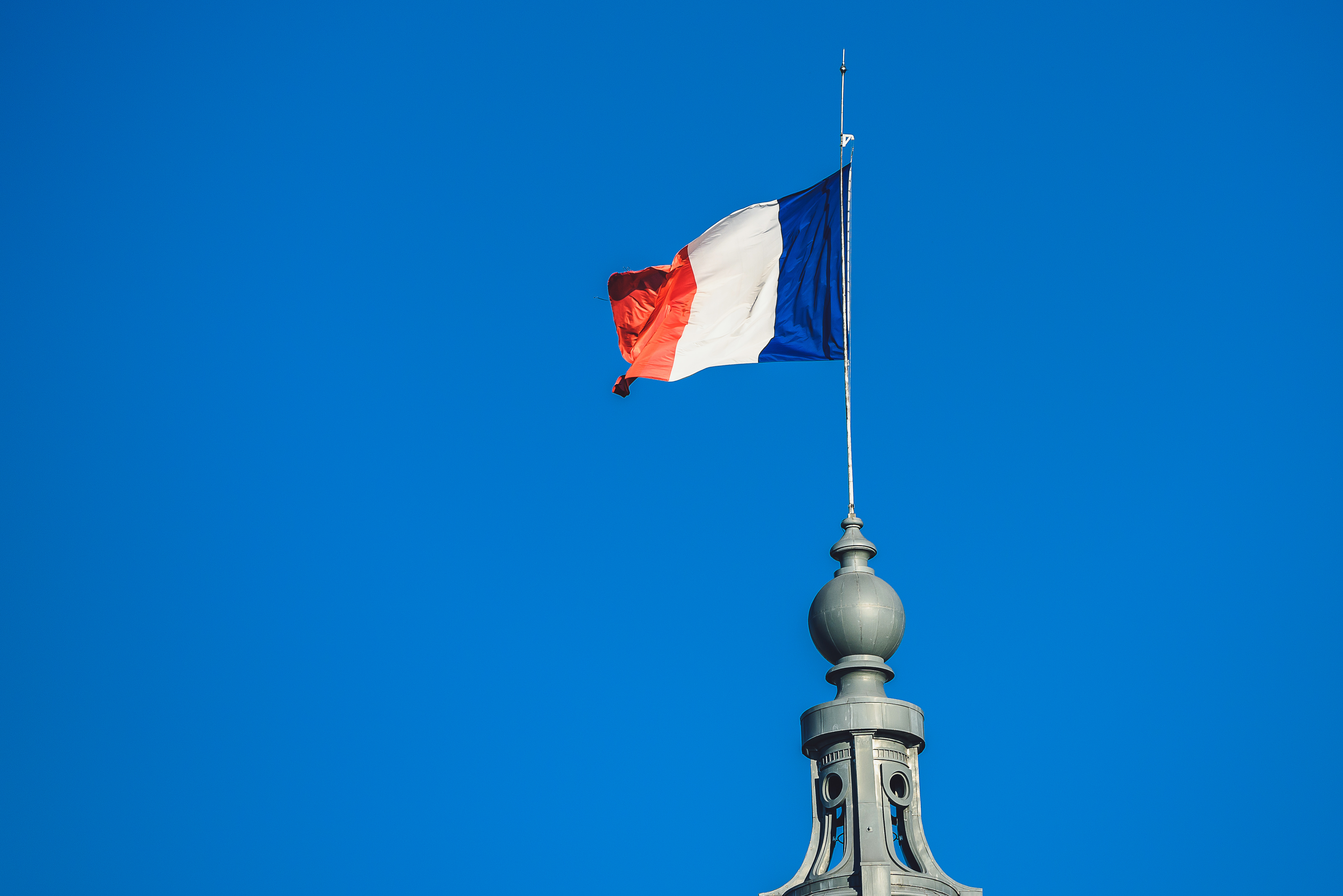 low angle view flag against blue sky